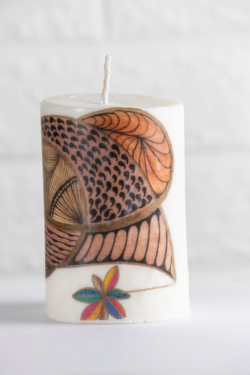 White vegetable wax pillar candle with no aroma and drawing